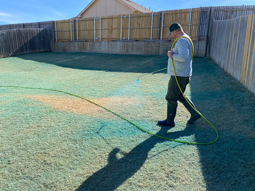 Willis lawn technician spraying weed spray tracker on grass