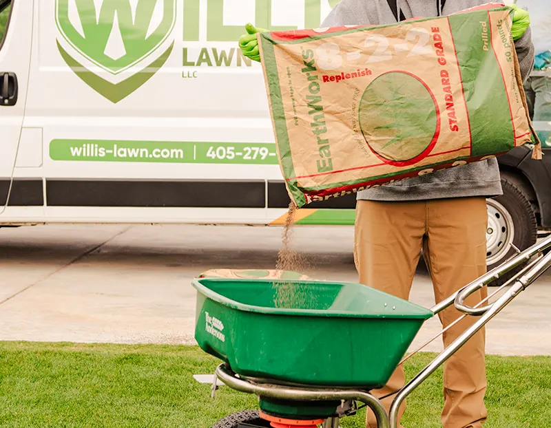 Willis Lawn Services tech adding Earthworks Replenish Soil Condition to spreader