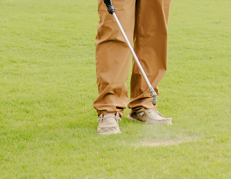 Closeup of Willis Lawn Services tech spraying root booster Closeup of Willis Lawn Services tech spraying root booster