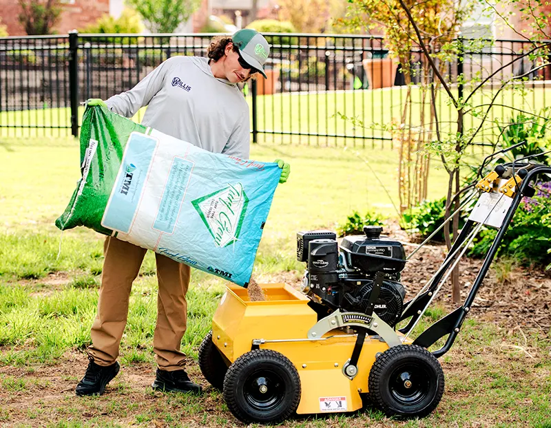 Willis Lawn Services tech loading fescue power seeder