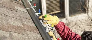 Gloved hands putting up Christmas lights Gloved hands putting up Christmas lights