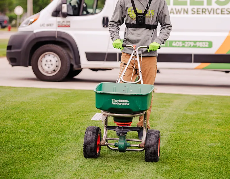 Spreading soil conditioner by Willis Lawn Services tech