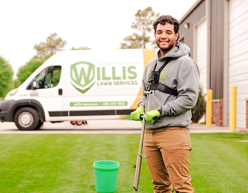Smiling Willis Lawn technician performing soil testing on Oklahoma City yard